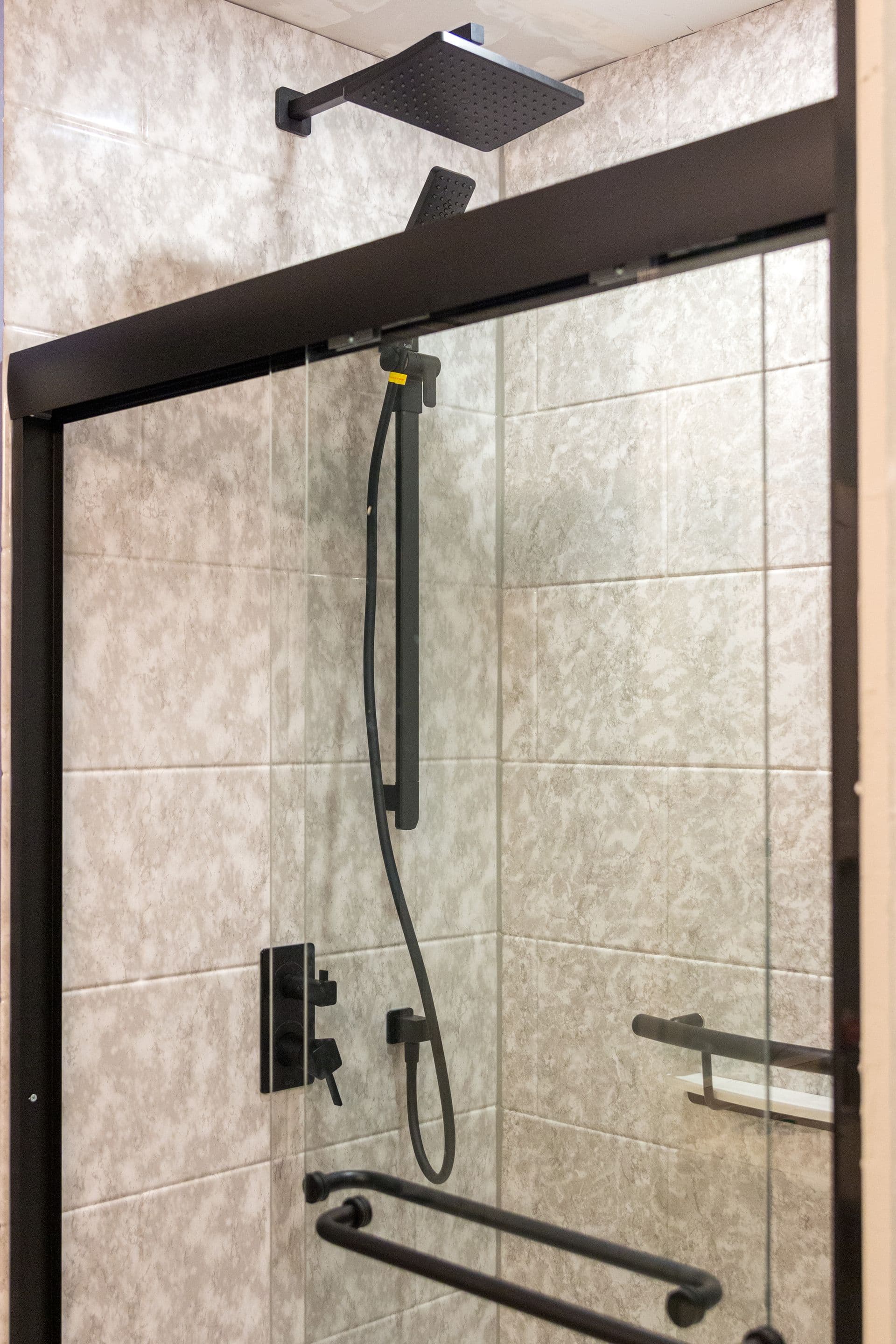 A modern square shower head with glass fixture renovated by Bytown Bath